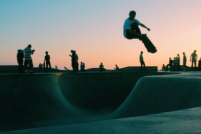 人做技巧滑板公园在日落
